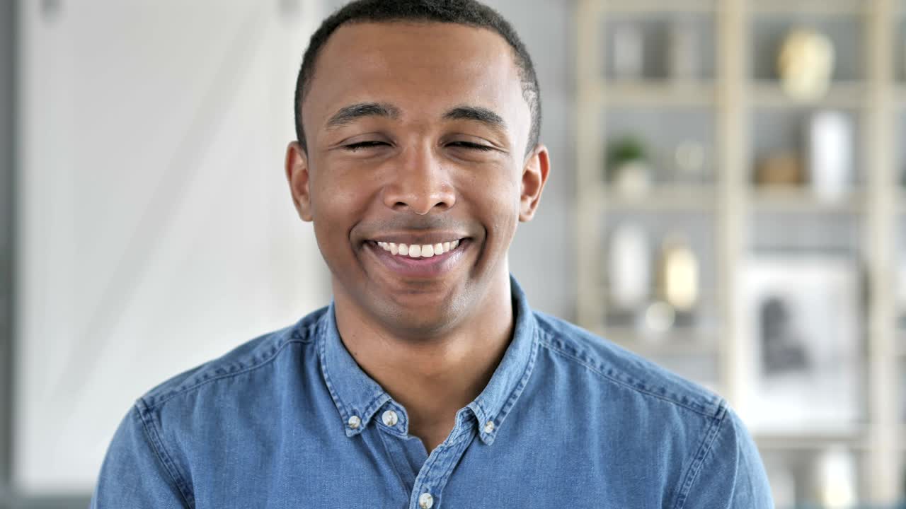 Thumbs Up by Young African Man Looking at Camera