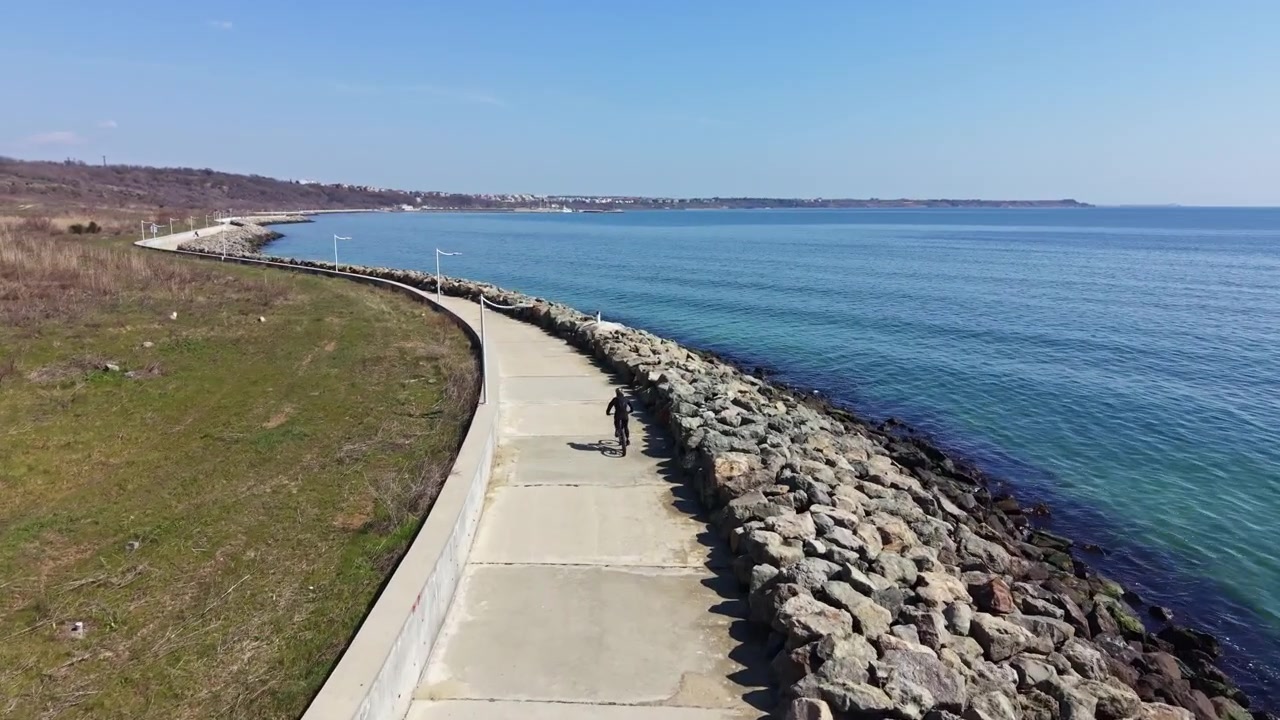 Vue aérienne d'un cycliste roulant le long d'un sentier côtier au bord de la mer