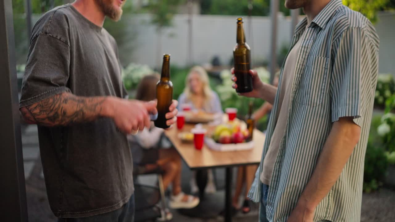 amigos disfrutando de una barbacoa de verano con cervezas en su patio trasero