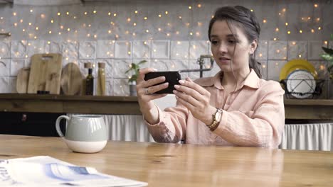 mujer usando un teléfono inteligente en la cocina