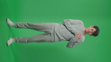 Full Body Of Proud Asian Man Touching Her Chest While Standing In Front Of Green Screen Background
