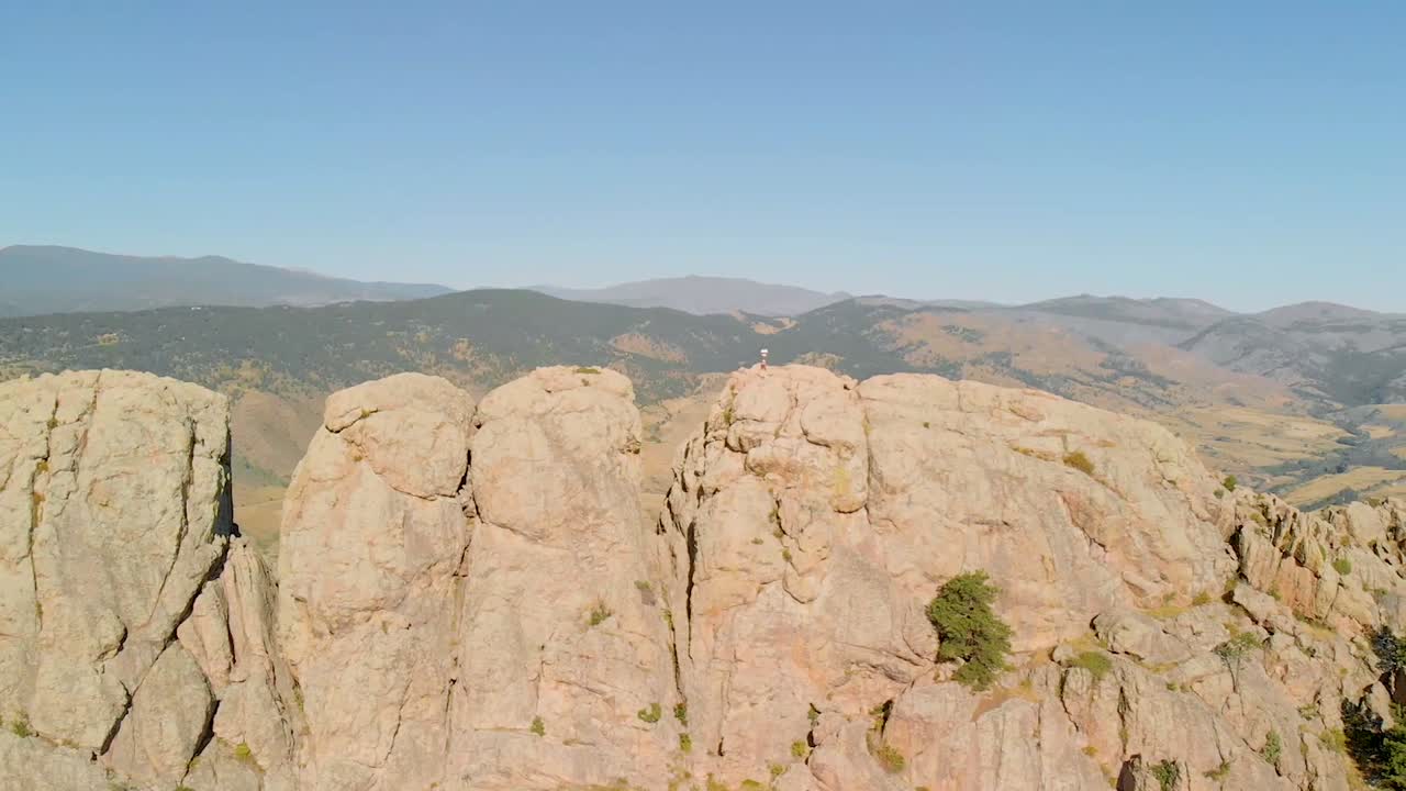 toma de drones de terreno montañoso, excursionistas y paisaje urbano en la distancia