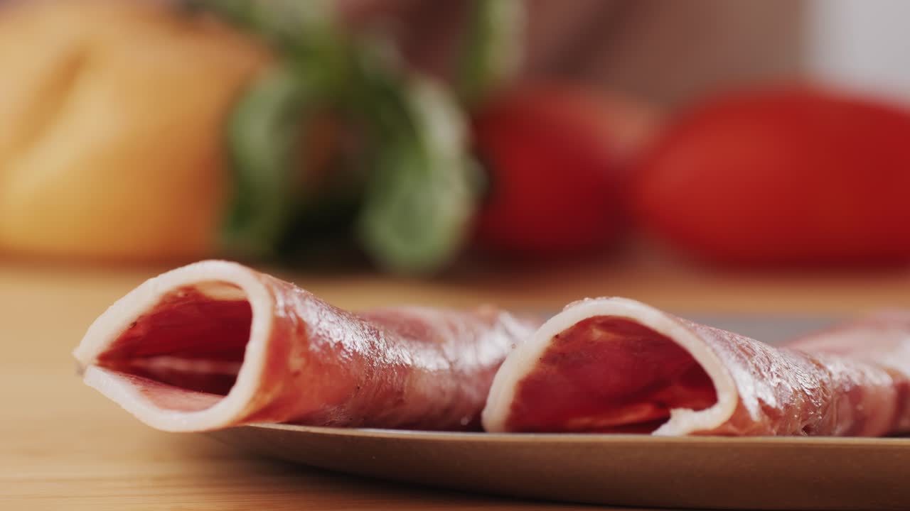 black bull sausage ham, tongue pork dry-cured sausage on a black background, traditional spanish delicatessen food, close up.