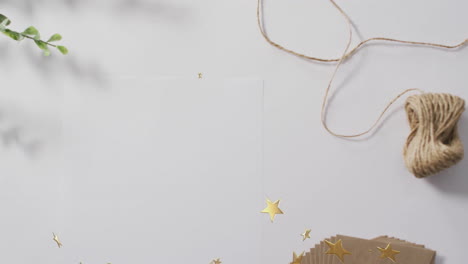 golden stars and twine animation over white background with leaves and paper
