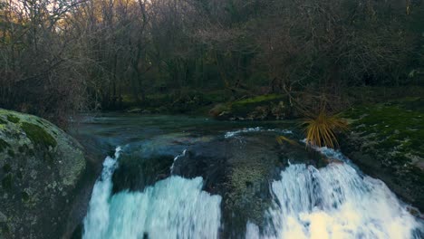 Fly-Over-Waterfall-Flowing-Into-Rocky-River-In-Fervenza-Da-Noveira,-A-Coruña,-Spain