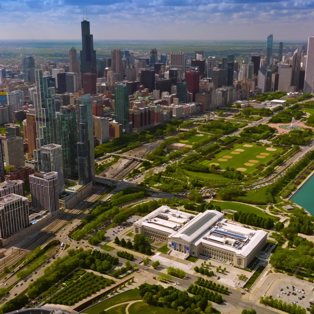 Breath-taking view of Chicago panorama. Stunning scenery of green Millennium Park at the lake waterfront. Skyscrapers surrounding park