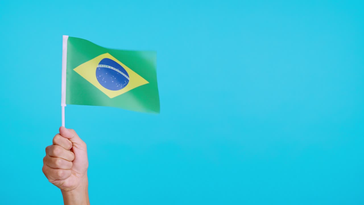 Wind waving a brazilian pennant holding by a person