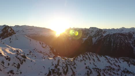 sunrise between mountain peaks at chamrousse, france alps, aerial dolly out shot
