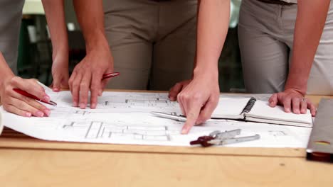 equipo de arquitectos estudiando planos
