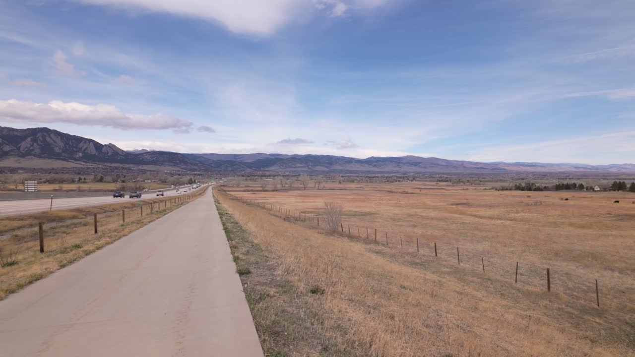US 36 Bikeway Parallel To Denver Boulder Turnpike With Light Traffic In Denver, Colorado. Flatirons Revealed In Background. panning shot