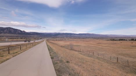 us 36 bikeway parallel to denver boulder turnpike with light traffic in denver, colorado. flatirons revealed in background. panning shot