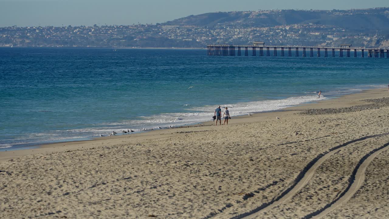 캘리포니아 산 클레멘테에서 함께 해변을 따라 걷는 커플