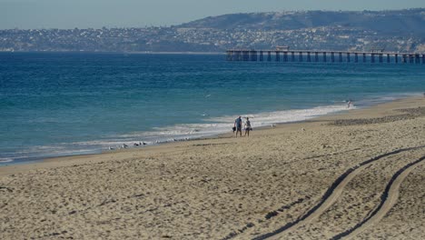 Una-Pareja-Caminando-Juntos-Por-La-Playa-En-San-Clemente,-California