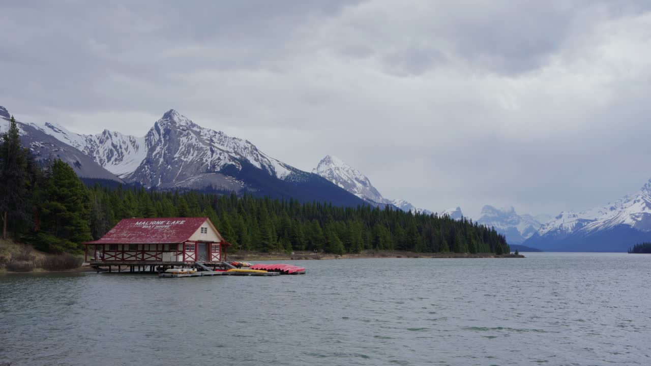 Capanna delle barche del lago Maligne con montagne innevate nel Parco Nazionale Jasper, Canada