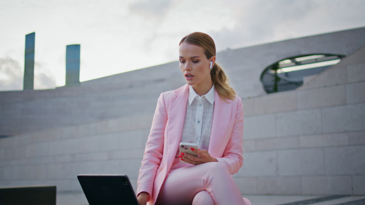 Woman lawyer consulting online using tablet on town bench. Lady talking at video