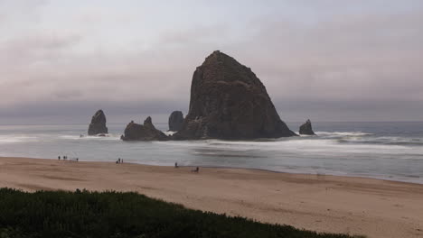 toma amplia de cannon beach y la famosa roca pajar con gente en la playa