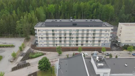 aerial shot of apartment house with forest in the background in summer