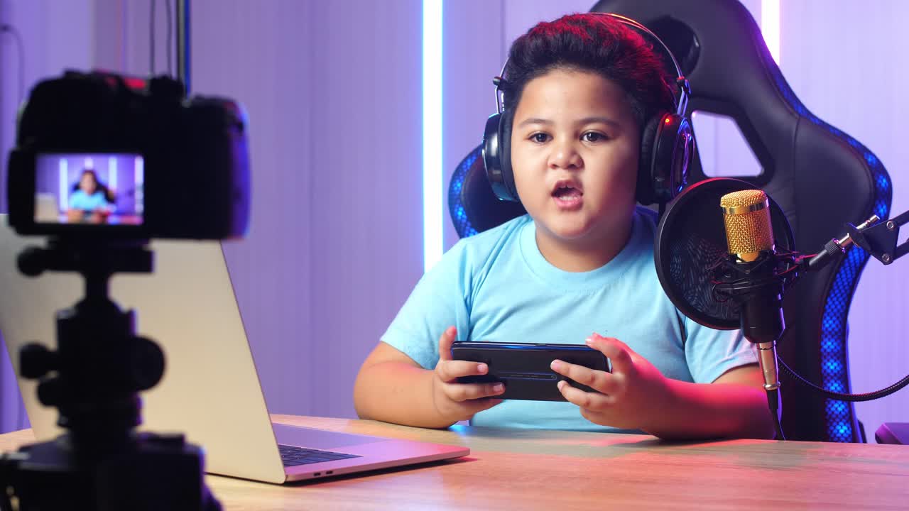 Asian Little Boy Holding Mobile Phone And Talking To Camera While Live Stream