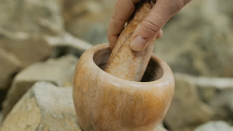 hand using a mortar and pestle