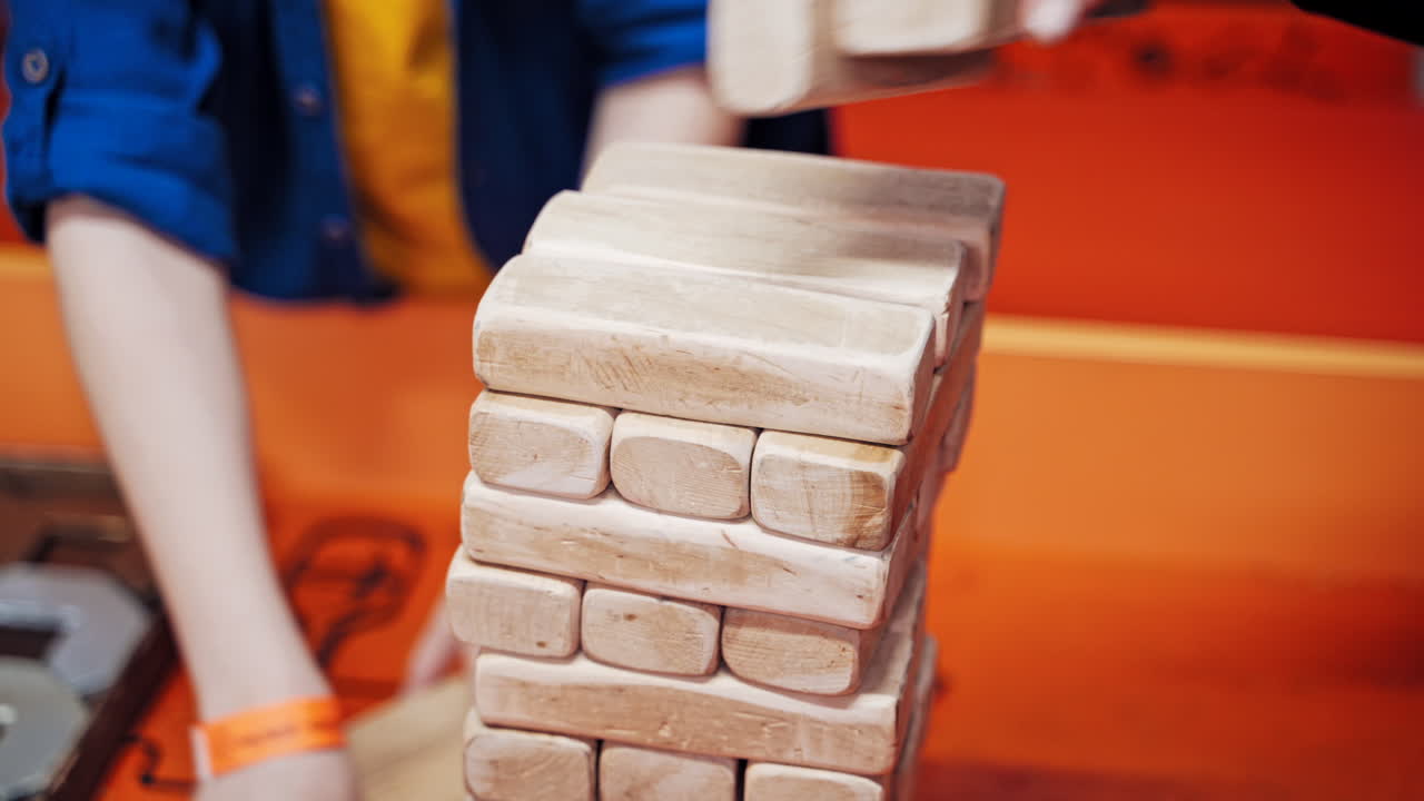 The family plays wooden tower table game together.