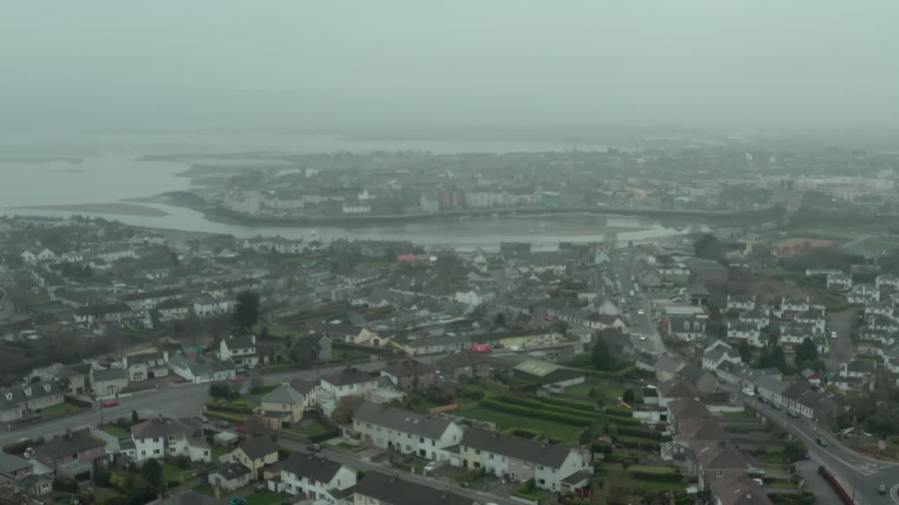 Aerial still establishing shot of rural city by the sea on overcast day