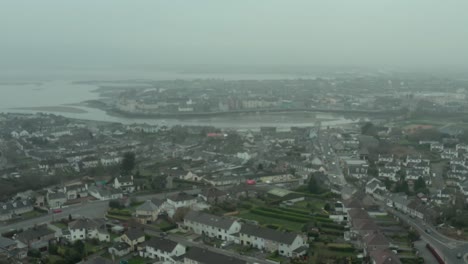 aerial still establishing shot of rural city by the sea on overcast day
