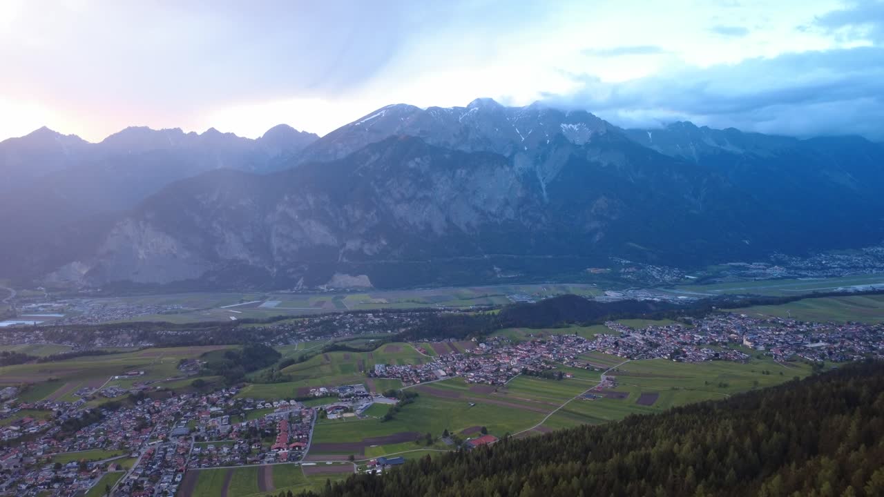 Vast valley in Austria under a glowing alpine sunset sky.