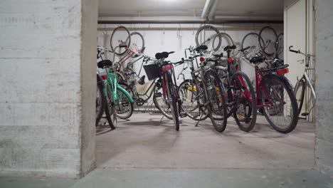 Man-walking-a-bicycle-in-a-bicycle-storage-facility
