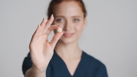 redheaded doctor in front of camera on gray background.