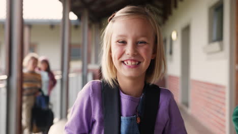 a young girl with a backpack in a school hallway