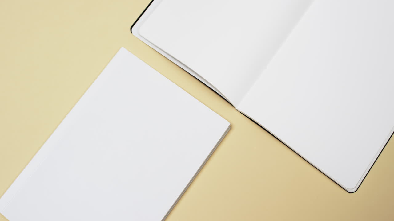 Video of books with white blank pages and copy space on yellow background