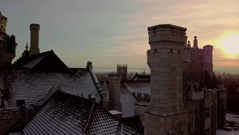 torres y techo de tejas de un castillo escénico al atardecer, deslizamiento de drones a la derecha