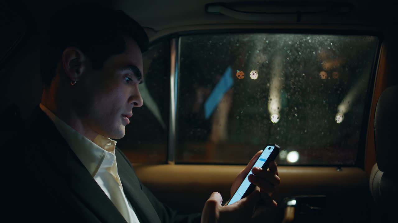 잘생긴 사업가 스마트폰 차량 클로즈업. 택시에 앉아 있는 매니저