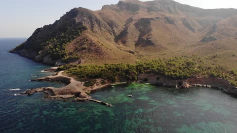 Sweeping-aerial-of-boats-in-Platja-des-Calo-off-rugged-Mallorca-coast