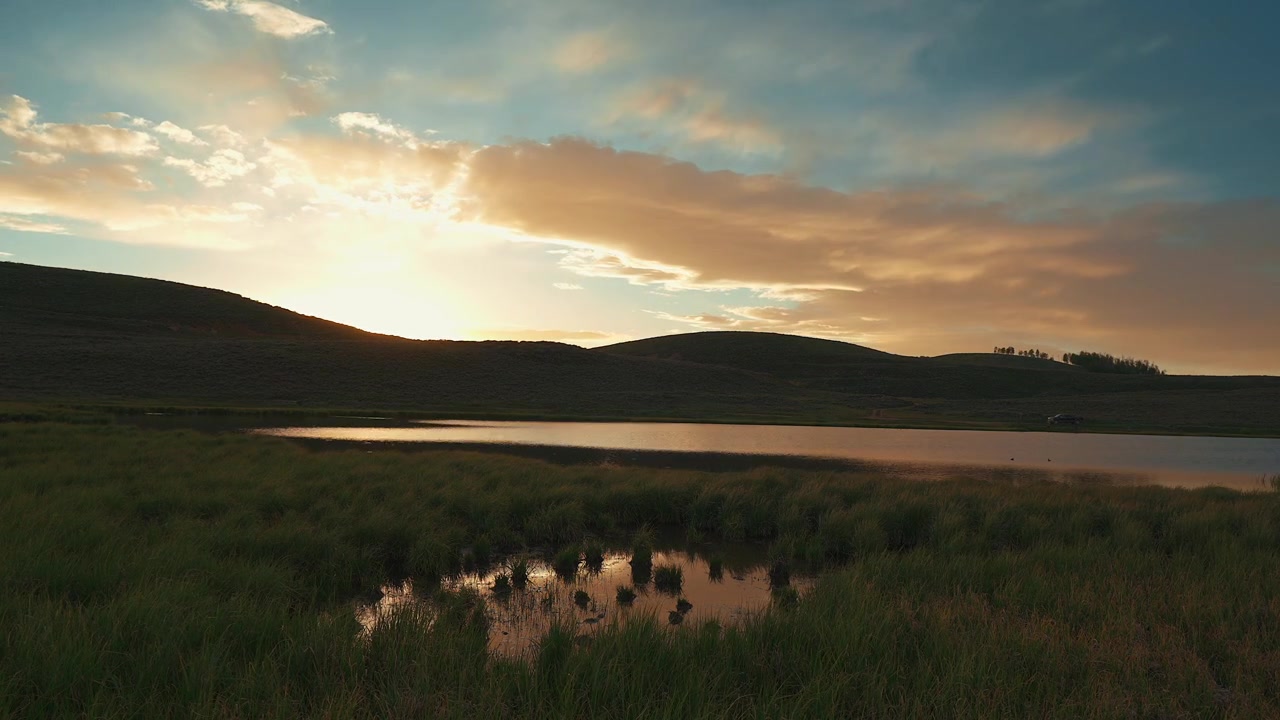 Timelapse di un lago e delle montagne circostanti al tramonto in campagna