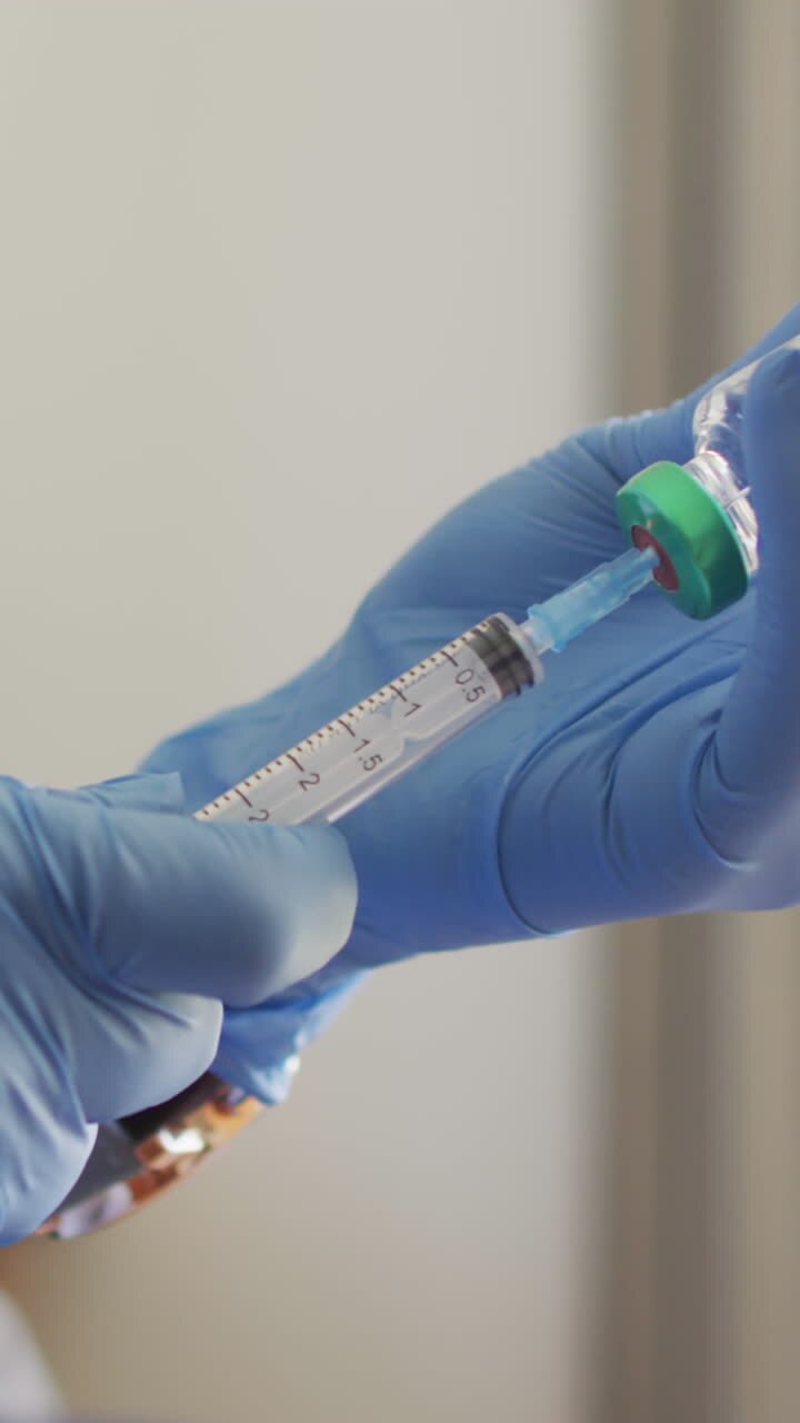 Video of hands of biracial female doctor preparing vaccine