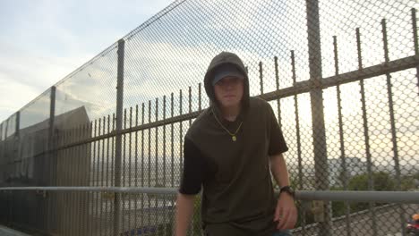 man freestyle hip hop dancing across freeway overpass in city