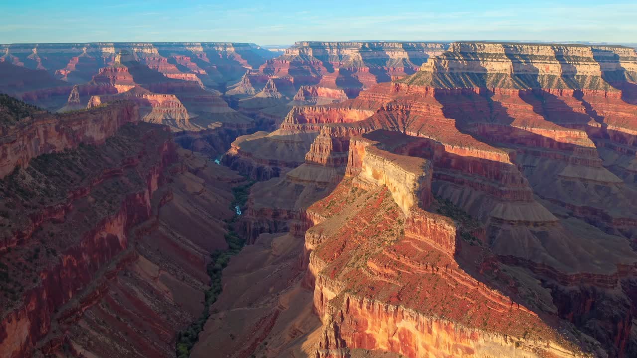 Aerial video captures the majestic Grand Canyon at sunset, highlighting its vast, layered rock