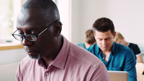 Pull-Focus-Shot-Of-Man-Studying-In-Adult-Education-Class