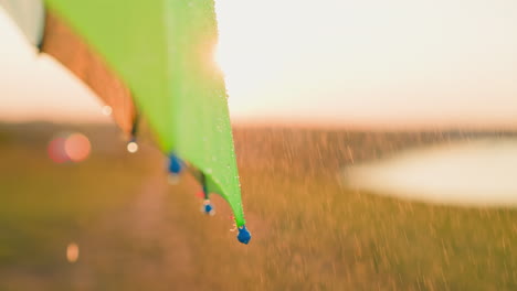 las gotas de lluvia caen por el borde del paraguas. el paraguas libera una suave corriente de gotas de agua que crea