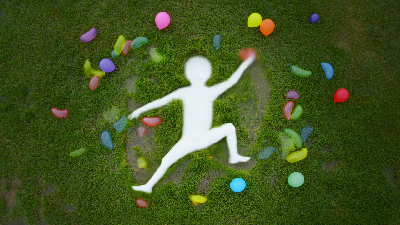 Tampak atas menunjukkan siluet manusia putih buram tergeletak di rumput hijau lebat dengan lengan terentang dan kaki terbuka, dikelilingi oleh balon warna-warni dan pecahan balon air yang robek dalam nuansa musim panas yang cerah.