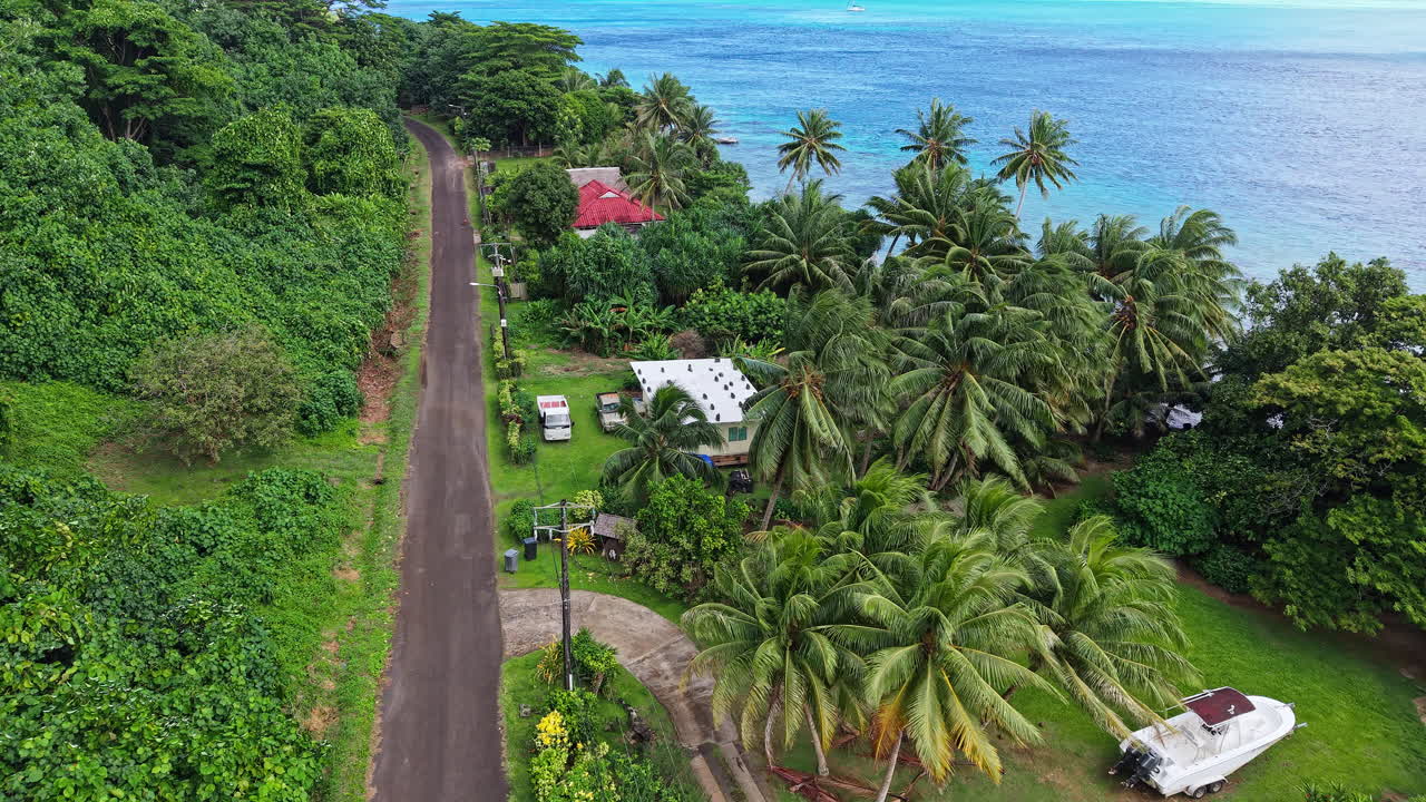 Huahine Island, French Polynesia. Drone Shot of Beachfront Houses, Road and Blue Lagoon