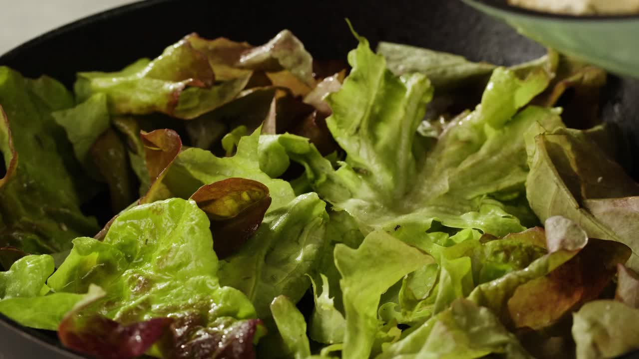 Fried tofu with sesame seeds and spices on cast iron pan, cooking japanese salad. Healthy ingredient for cooking vegan vegetarian diet food. Roasted tofu over black background.