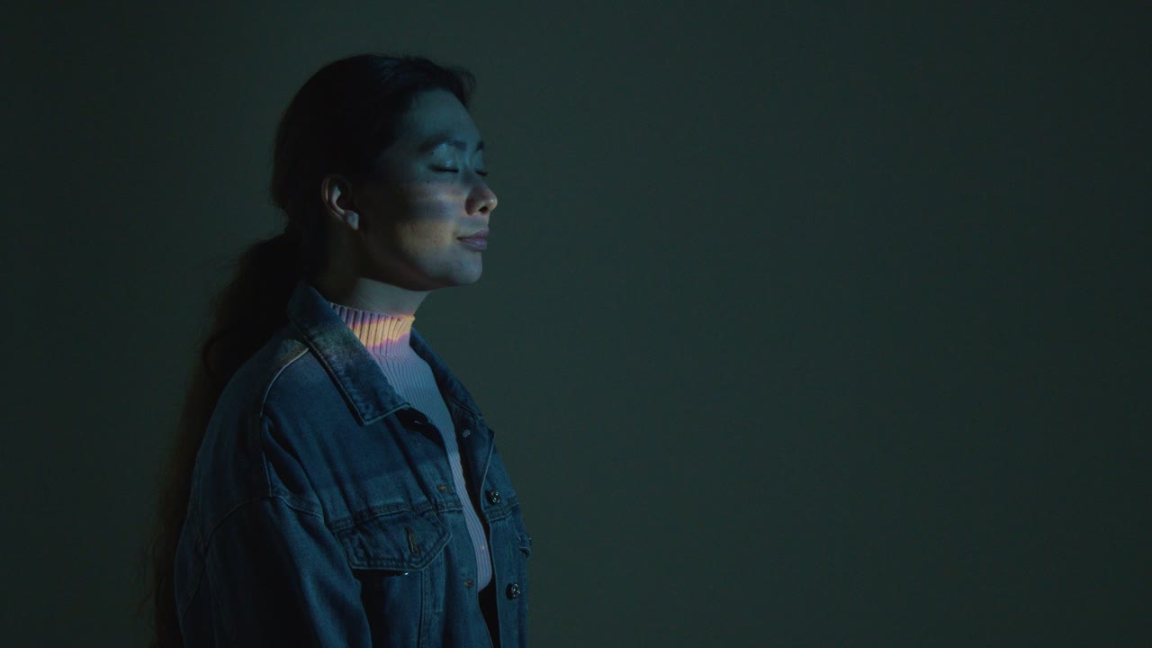 Woman Visiting Immersive Art Exhibition With Images Being Projected Onto Her Face