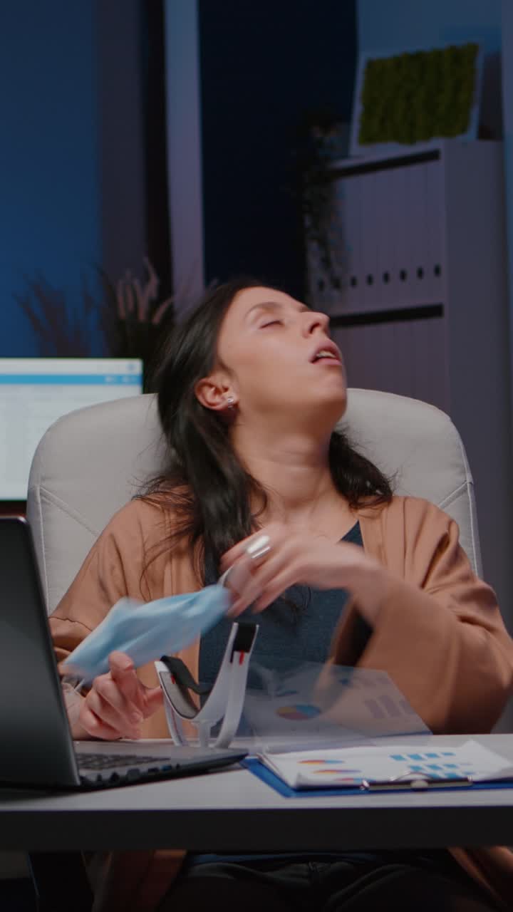 Vertical video Workaholic tired businesswoman with face mask and visor against covid19