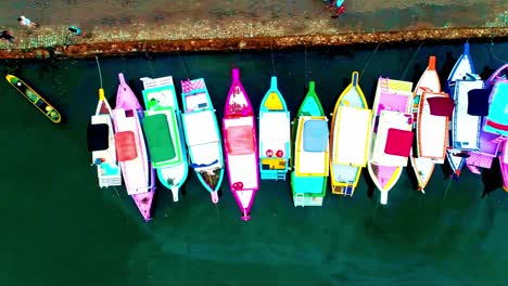 Tiro-Aéreo-De-Pájaros-Volando-Sobre-Barcos-Tradicionales-Atracados-En-Paratay,-Brasil