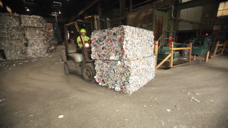 un cargador basculante mueve latas de aluminio en un centro de reciclaje