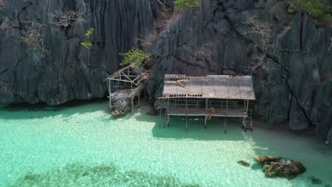 aerial view of lonely female in hut on exotic hidden banul beach, coron island, philippines