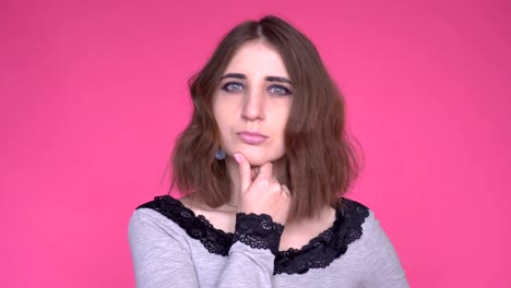 face expressions and emotions. thoughtful young woman holding hand under her head is thinking.