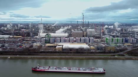 emissions and industrial shipping barge at chemical plant complex, drone view